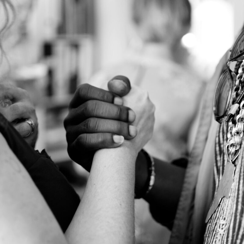 grayscale photo of man and woman holding their hands